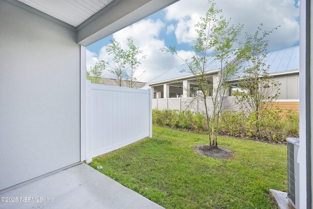 view of yard with fence and central AC