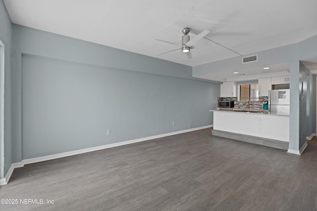 731 1st St S Unit 311, Jacksonville Beach, FL 32250 - unfurnished living room featuring baseboards, dark wood-style floors, ceiling fan, and visible vents