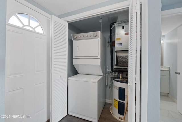 731 1st St S Unit 311, Jacksonville Beach, FL 32250 - laundry area with water heater, baseboards, stacked washer / drying machine, and laundry area
