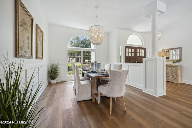dining area with ornate columns, baseboards, an inviting chandelier, and wood finished floors