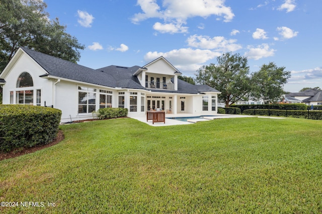 rear view of house with french doors, a lawn, a patio area, a fenced in pool, and stucco siding