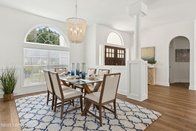 4520 Swilcan Bridge Ln N, Jacksonville, FL 32224 - dining space featuring decorative columns, wood finished floors, baseboards, arched walkways, and a chandelier