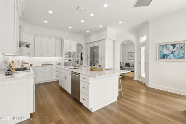 4520 Swilcan Bridge Ln N, Jacksonville, FL 32224 - kitchen with arched walkways, dishwasher, crown molding, a breakfast bar area, and an island with sink
