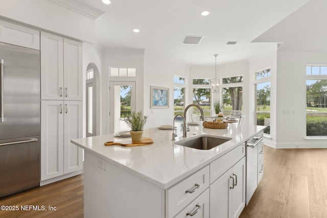 4520 Swilcan Bridge Ln N, Jacksonville, FL 32224 - kitchen with stainless steel appliances, a sink, wood finished floors, light stone countertops, and ornamental molding