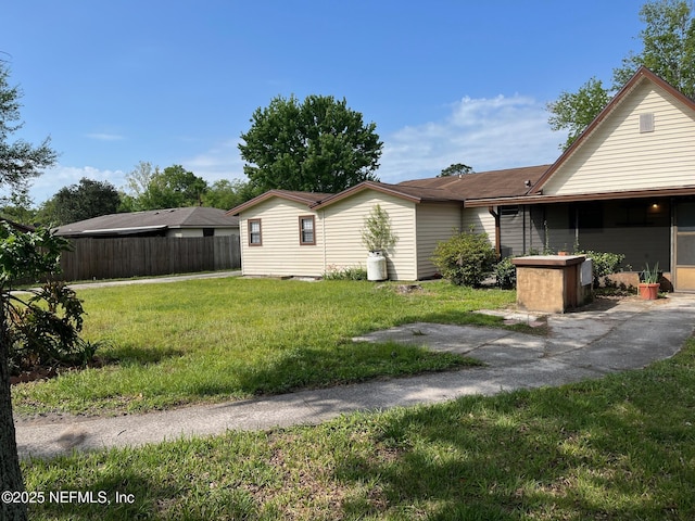view of home's exterior with fence and a lawn