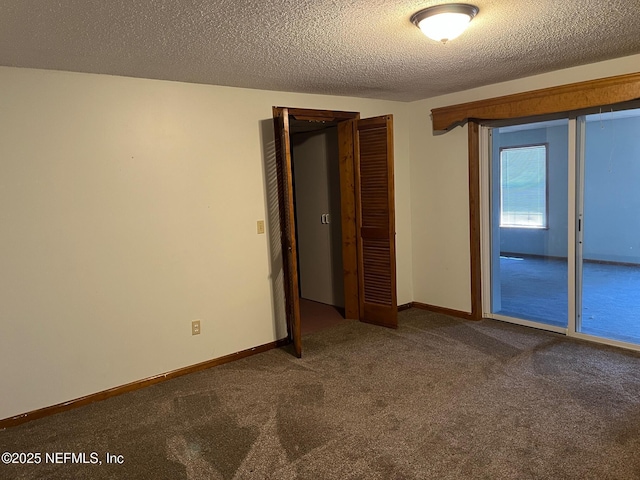 unfurnished bedroom featuring carpet floors, a textured ceiling, baseboards, and a closet