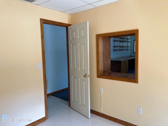 spare room with baseboards and light tile patterned flooring
