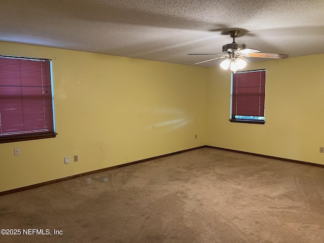 spare room featuring baseboards, a textured ceiling, carpet, and ceiling fan