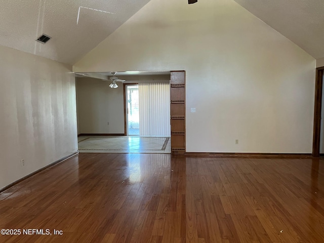 empty room featuring a ceiling fan, high vaulted ceiling, baseboards, and hardwood / wood-style floors