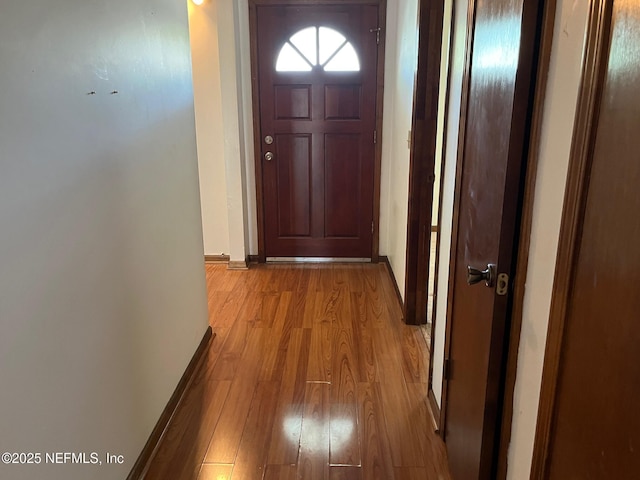 entryway with baseboards and light wood finished floors