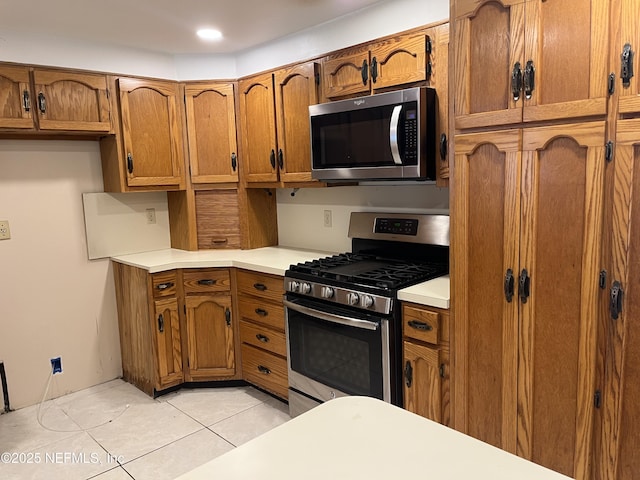 1933 Timucua Trl, Middleburg, FL 32068 - kitchen featuring appliances with stainless steel finishes, brown cabinets, light countertops, and light tile patterned floors