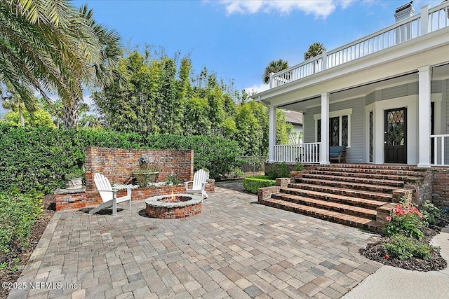 view of patio / terrace featuring an outdoor fire pit and a porch