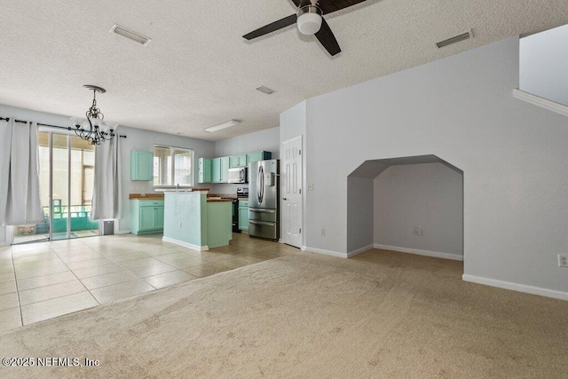 2338 Red Moon Dr, Jacksonville, FL 32216 - unfurnished living room featuring light tile patterned floors, light carpet, ceiling fan with notable chandelier, and visible vents