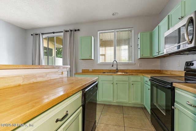 2338 Red Moon Dr, Jacksonville, FL 32216 - kitchen with a sink, wood counters, black appliances, and green cabinetry