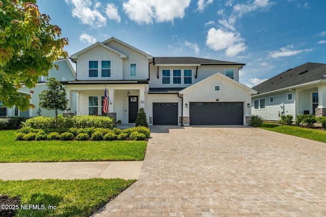106 Anclote Way, Saint Augustine, FL 32092 - craftsman-style house with decorative driveway, a porch, a front lawn, stone siding, and an attached garage