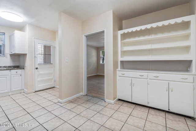 3047 Post St, Jacksonville, FL 32205 - kitchen with light tile patterned flooring, white cabinetry, open shelves, and a wealth of natural light