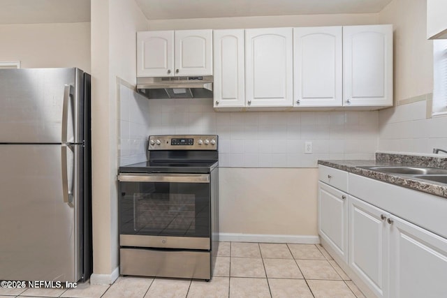 3047 Post St, Jacksonville, FL 32205 - kitchen with white cabinets, stainless steel appliances, tasteful backsplash, under cabinet range hood, and light tile patterned floors