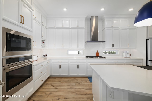 489 Windley Dr, Saint Augustine, FL 32092 - kitchen with tasteful backsplash, wall chimney exhaust hood, light countertops, white cabinetry, and stainless steel appliances