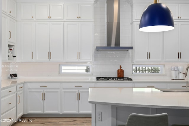 489 Windley Dr, Saint Augustine, FL 32092 - kitchen with light countertops, gas stovetop, wall chimney exhaust hood, and white cabinetry