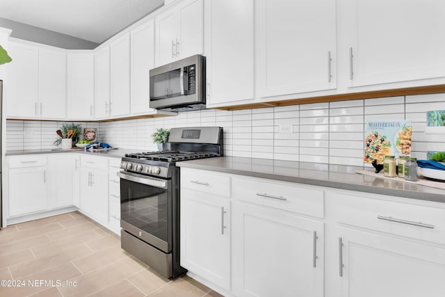 kitchen with white cabinetry, backsplash, and appliances with stainless steel finishes