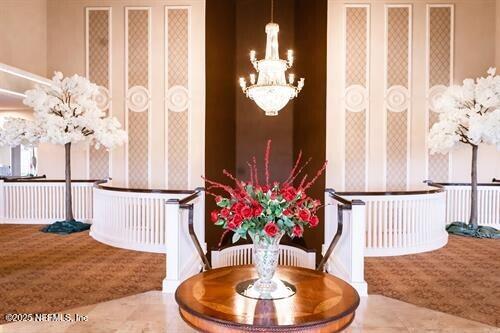 interior space featuring a chandelier and wallpapered walls