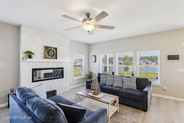 29 Stargaze Ln, Saint Augustine, FL 32095 - living room with baseboards, light wood-style flooring, a ceiling fan, and a tile fireplace