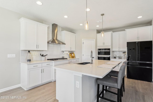 29 Stargaze Ln, Saint Augustine, FL 32095 - kitchen with a sink, wall chimney range hood, freestanding refrigerator, backsplash, and light wood finished floors