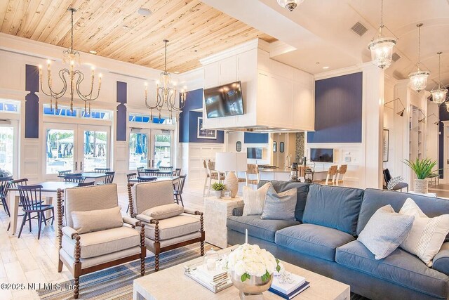 29 Stargaze Ln, Saint Augustine, FL 32095 - living area featuring a decorative wall, crown molding, a chandelier, a high ceiling, and french doors