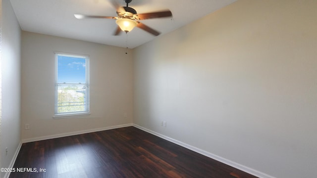empty room with a ceiling fan, dark wood-style flooring, and baseboards