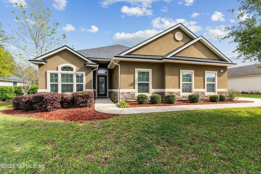 3641 Oglebay Dr, Green Cove Springs, FL 32043 - view of front of house featuring a front yard, stucco siding, and stone siding