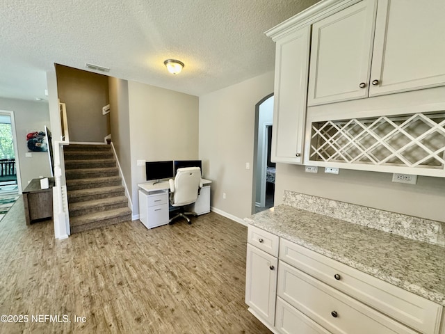 15949 Lexington Park Blvd, Jacksonville, FL 32218 - office featuring a textured ceiling, light wood-style flooring, baseboards, visible vents, and arched walkways