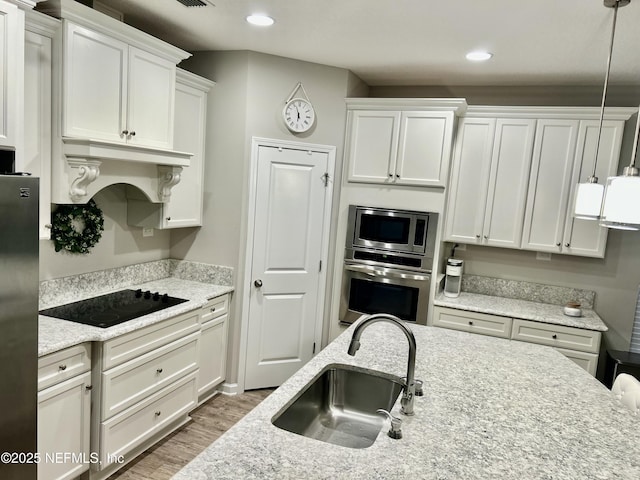 15949 Lexington Park Blvd, Jacksonville, FL 32218 - kitchen featuring custom range hood, white cabinets, a sink, and stainless steel appliances