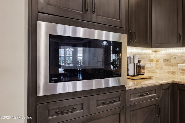464 Deer Valley Dr, Ponte Vedra, FL 32081 - interior details with light stone counters, dark brown cabinetry, built in microwave, and decorative backsplash
