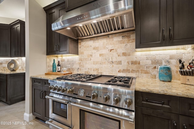 464 Deer Valley Dr, Ponte Vedra, FL 32081 - kitchen with tasteful backsplash, wall chimney range hood, range with two ovens, light stone countertops, and dark brown cabinetry