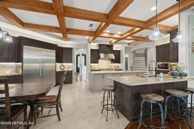 464 Deer Valley Dr, Ponte Vedra, FL 32081 - kitchen with a sink, built in appliances, a breakfast bar, under cabinet range hood, and arched walkways