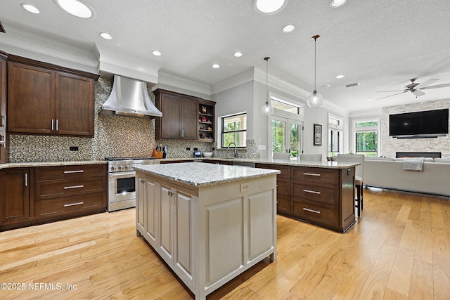 kitchen featuring open shelves, high end stainless steel range oven, a kitchen island, a ceiling fan, and wall chimney exhaust hood