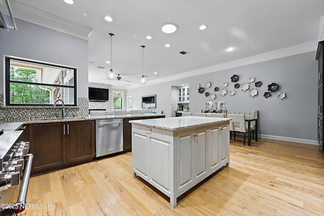kitchen featuring ornamental molding, ceiling fan, light wood finished floors, and appliances with stainless steel finishes