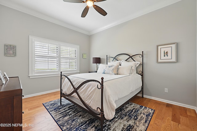 bedroom featuring baseboards, a ceiling fan, light wood-type flooring, and crown molding