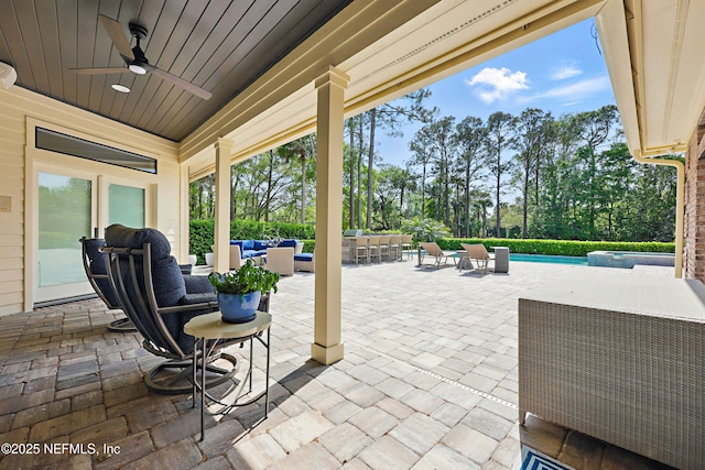 view of patio with a ceiling fan, a pool with connected hot tub, and an outdoor hangout area