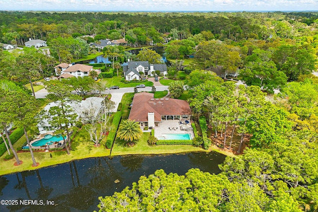 drone / aerial view with a water view and a view of trees