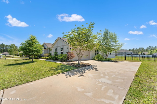 obstructed view of property featuring board and batten siding, driveway, fence, and a front yard