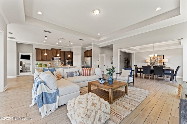 living room with light wood-style flooring, recessed lighting, and a raised ceiling