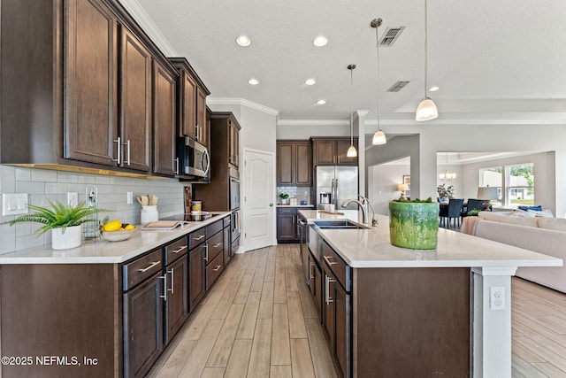 kitchen with visible vents, appliances with stainless steel finishes, and dark brown cabinetry