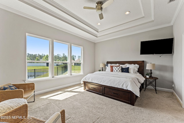 bedroom featuring a ceiling fan, crown molding, carpet floors, a raised ceiling, and baseboards