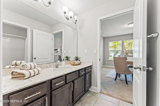 full bathroom with baseboards, tile patterned floors, vanity, and a textured ceiling