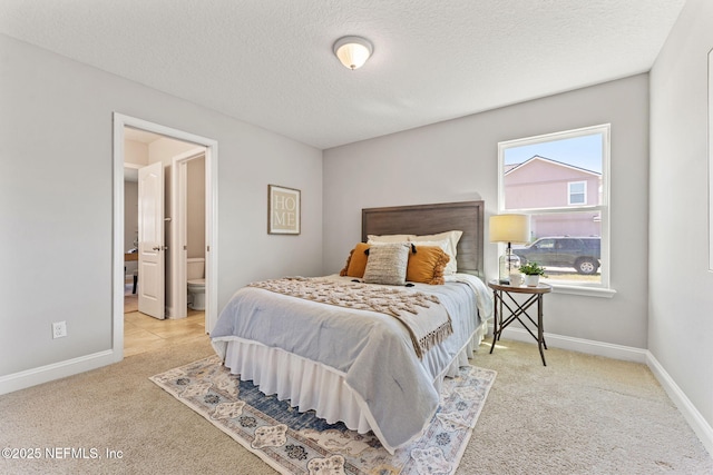 bedroom with ensuite bathroom, baseboards, carpet, and a textured ceiling