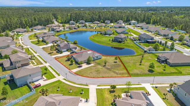bird's eye view featuring a water view, a residential view, and a wooded view