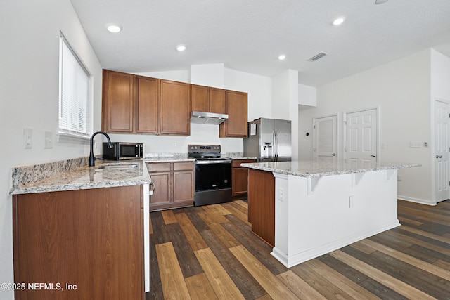 6387 Barrington Cv Ln, Jacksonville, FL 32218 - kitchen with appliances with stainless steel finishes, a sink, under cabinet range hood, a kitchen island, and a kitchen breakfast bar