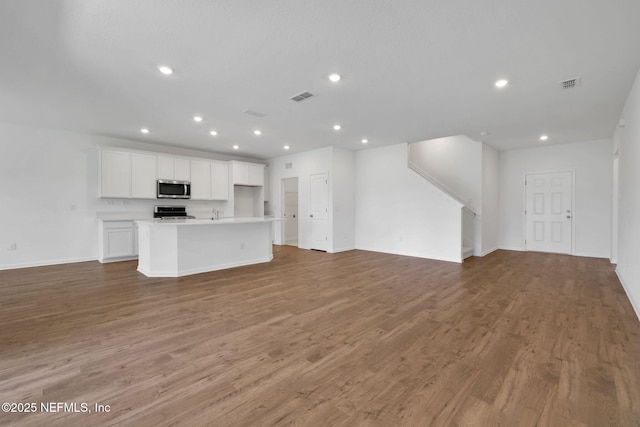356 Salazar St, Saint Augustine, FL 32095 - unfurnished living room featuring light wood-style flooring, recessed lighting, and stairway