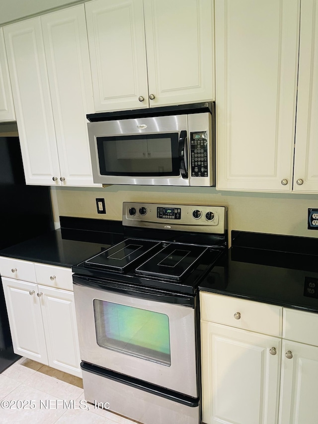 8539 Gate Pkwy W Unit 1616, Jacksonville, FL 32216 - kitchen with white cabinets, dark countertops, and appliances with stainless steel finishes